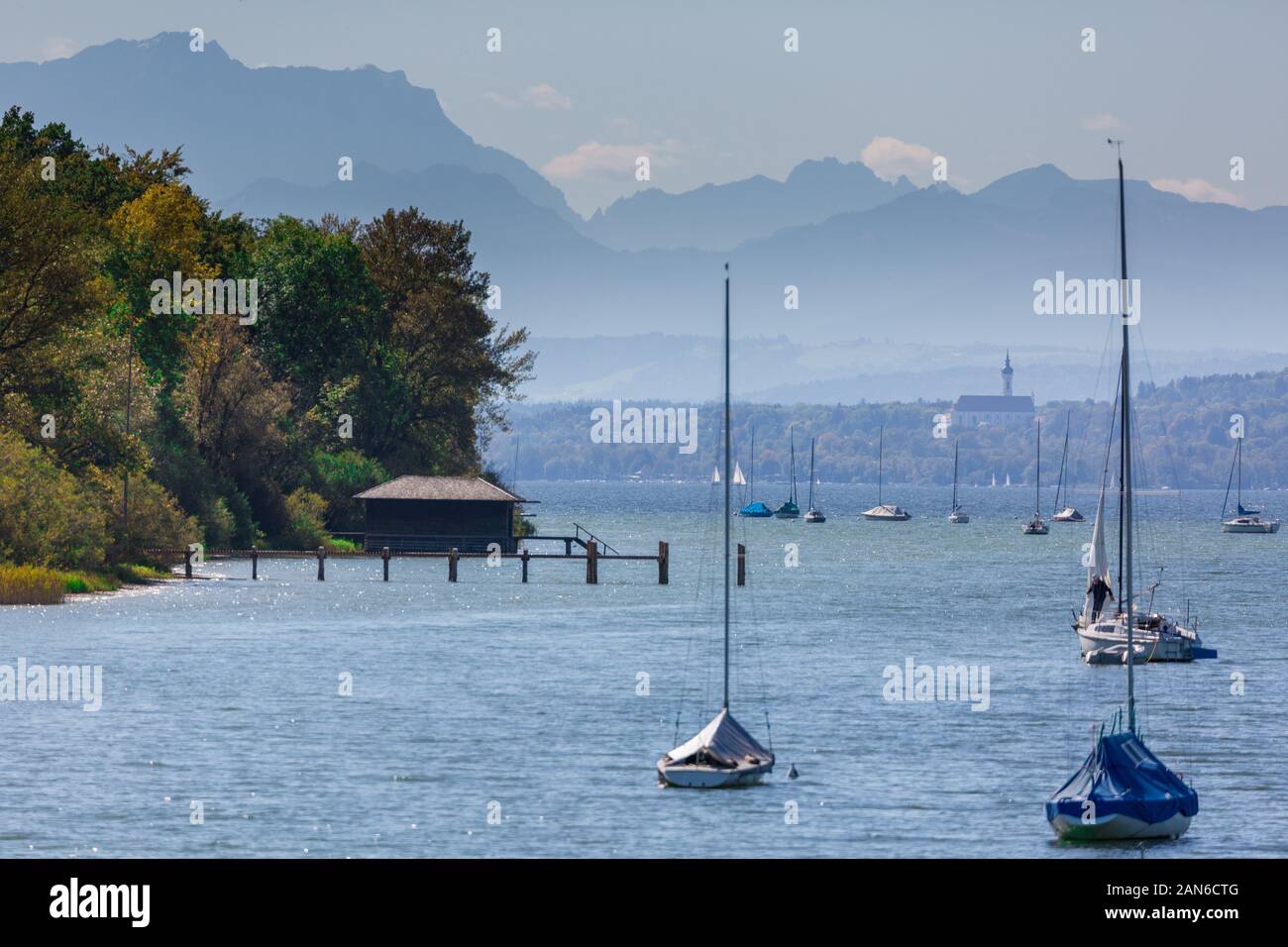 Blick auf den See mit Segelbooten und einem Bootshaus. Hintergrund: Bayerische alpen mit Deutschlands höchstem Berg, Zugspitze und Marienmünster Dießen Stockfoto