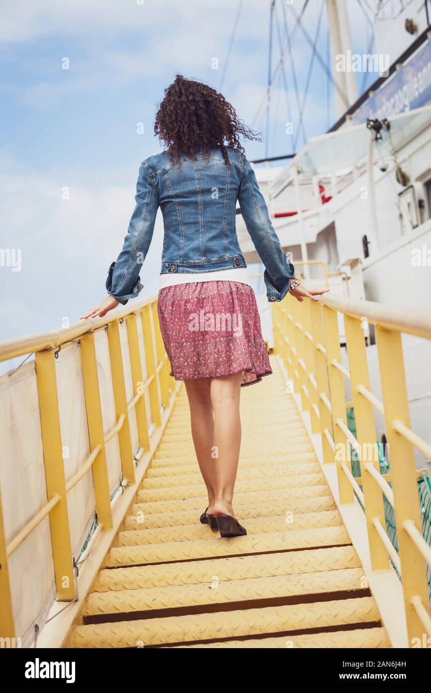 Attraktive Frau an Bord eines Schiffes durch die Gangway Stockfoto