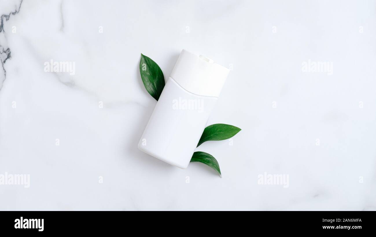 Gesichtsreiniger shampoo Badewanne Flasche container Branding mockup mit grünen Blättern auf Marmor Hintergrund. Flach, Ansicht von oben. Natürliche organische beauty Produ Stockfoto