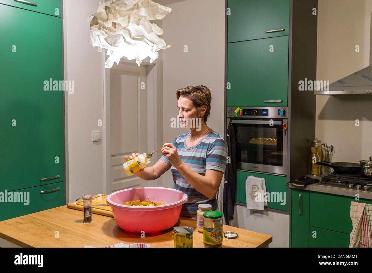 Frau prepareing Menge Essen in Kunststoff Wanne in der Küche Stockfoto