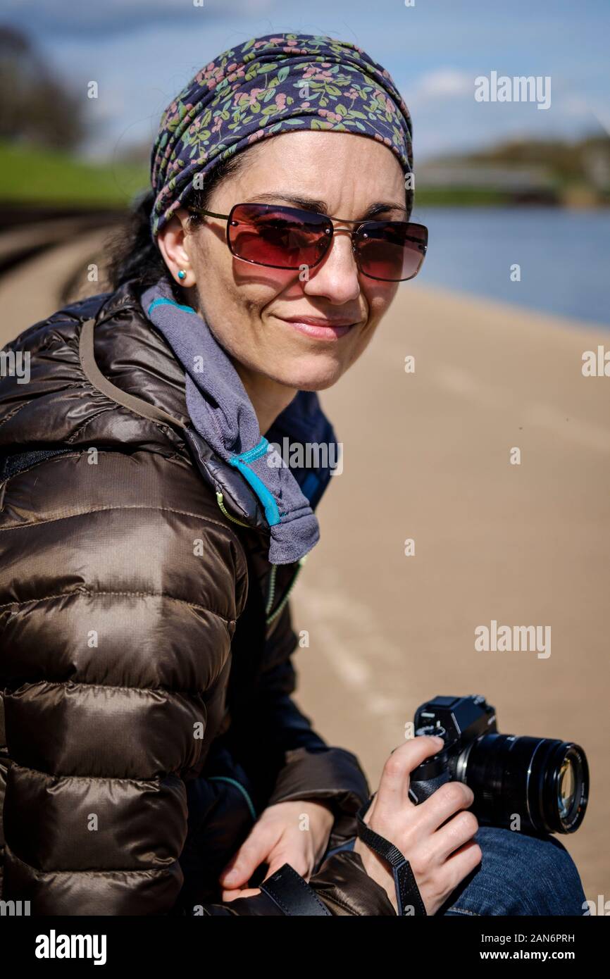 Portrait von Frau mittleren Alters, die eine Kamera, während gerade an der Fotograf, Stockfoto