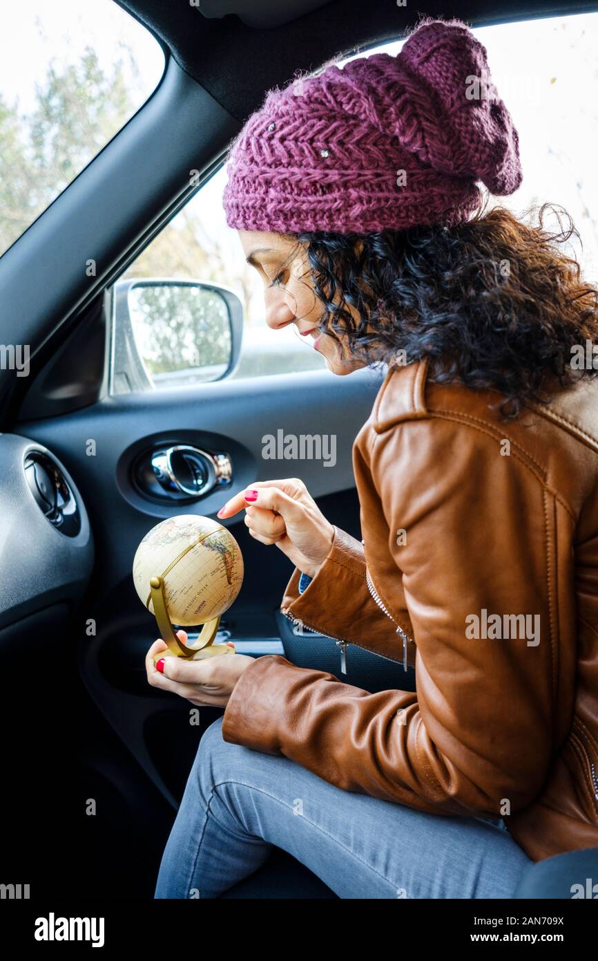 Sie prüft eine Weltkarte Kugel in einem Auto Stockfoto