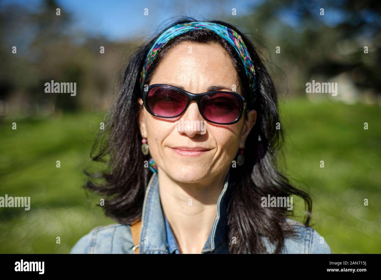 Zuversichtlich weiße Frau in ihren Dreißigern mit Sonnenbrille in die Kamera starrt Stockfoto