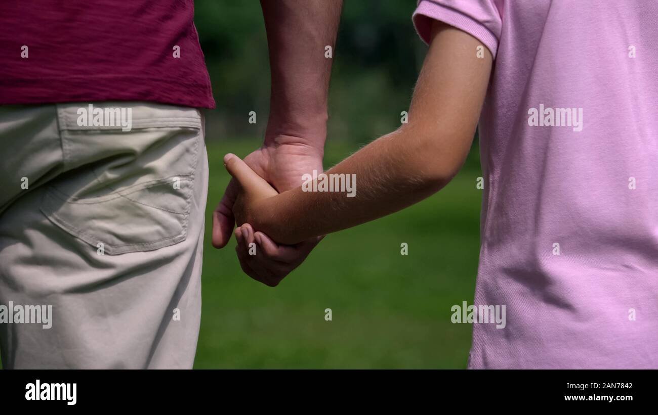 Mann und der Junge Hände halten und Weg, Familie Wochenende im Park, Support Stockfoto