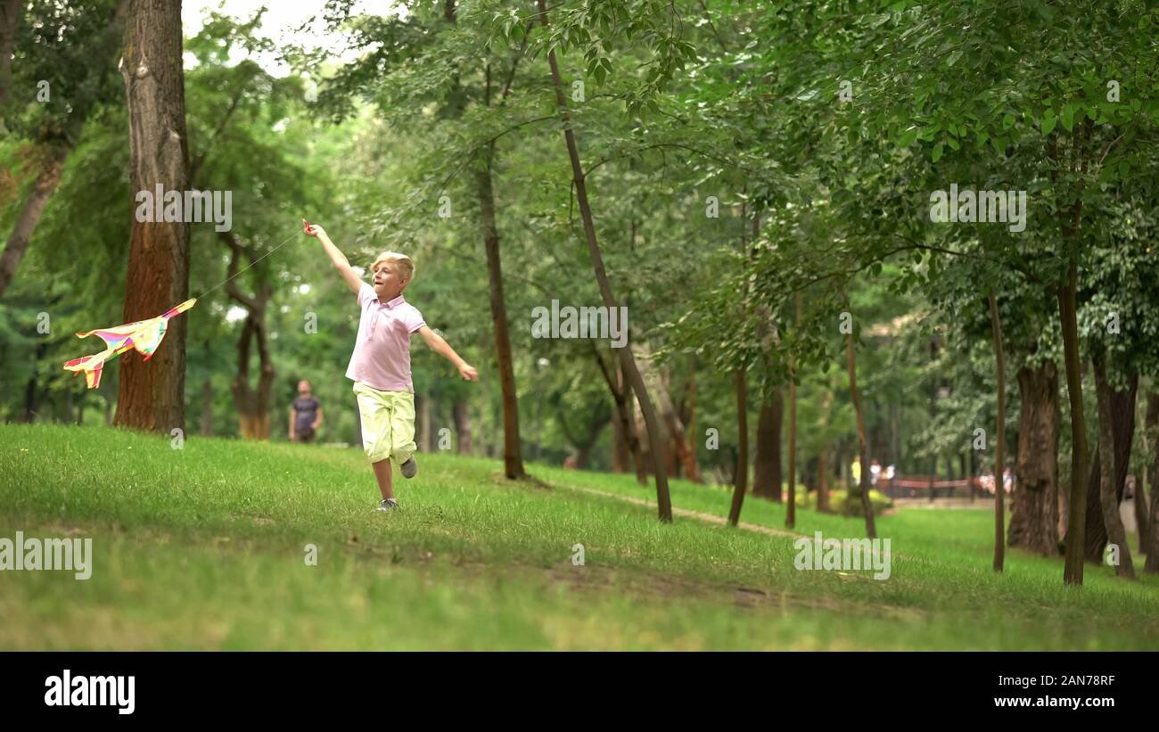 Happy Boy Einleitung Kite in Park, Freizeit Aktivität im Freien, unbeschwerten Kindheit Stockfoto