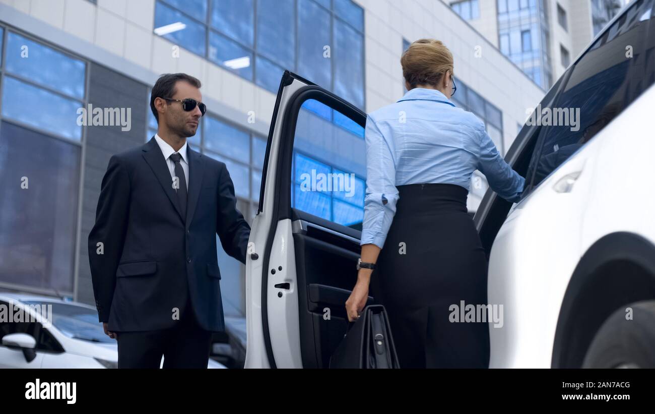 Persönliche Assistentin der Politikerin Öffnen der Fahrzeugtür zu seinem Chef, Service Stockfoto