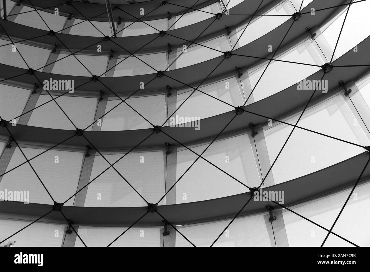 Schwarz-Weiß-Foto eines mit Glasrückseite errichteten Gebäudes mit Drähten Stockfoto