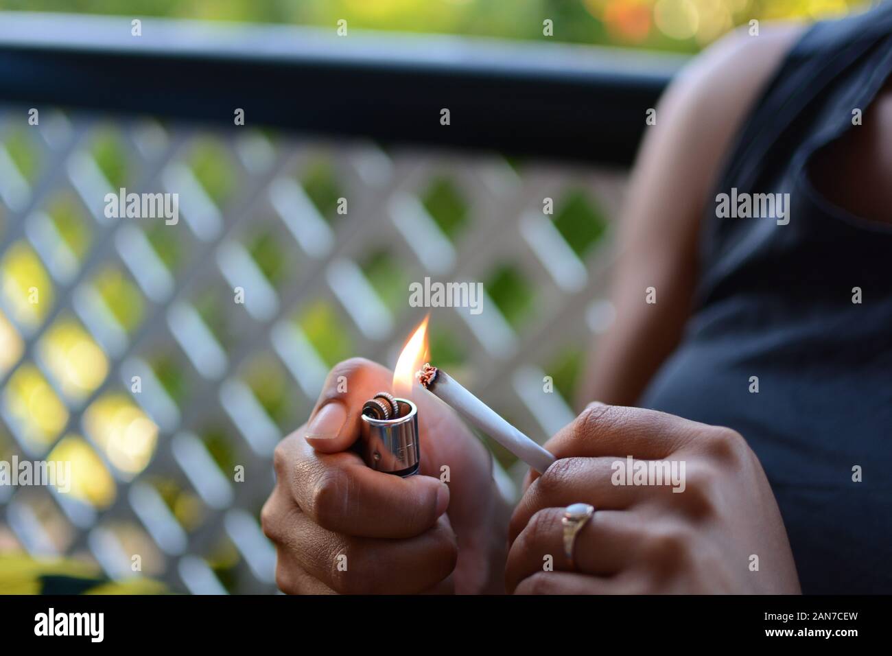 Frau mit Zigarette und Feuerzeug in der Hand Stockfoto