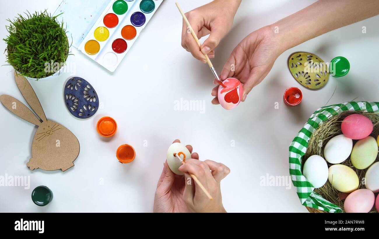 Frauen, die Hände auf den Tisch dekorieren Eier, Ostern Traditionen, familiäre Verbindung Stockfoto