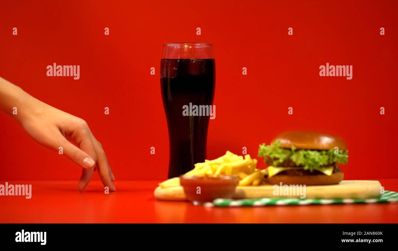 Winzige Frau Finger zu Fuß zu Fast Food und Soft Drinks, leckeres Gericht versucht Stockfoto