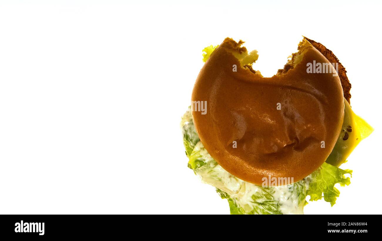 Cheeseburger liegen auf weißbeleuchteten Hintergrund Gebissen, testen die Qualität von Lebensmitteln Stockfoto
