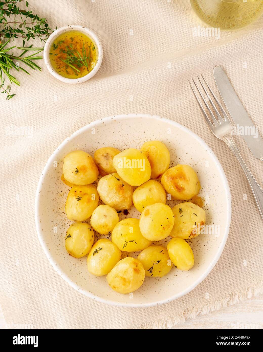 Im Ofen gebacken mit Gewürzen runden ganze Knollen der Kartoffel in der Platte auf White Background, Vertikal, Ansicht von oben Stockfoto