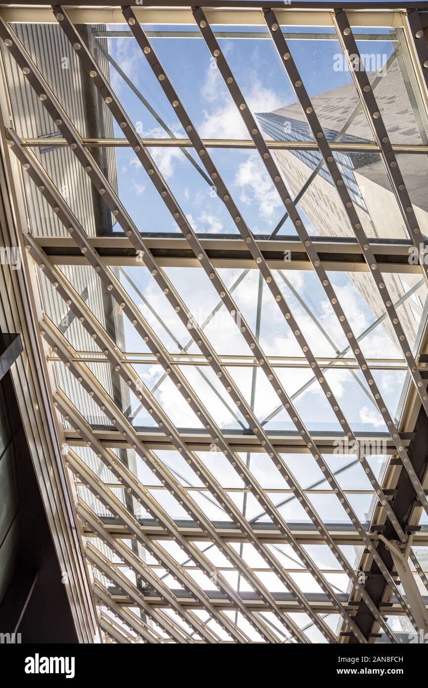 Glasdach. Blauen bewölkten Himmel durch eine Metallkonstruktion mit Glaspaneelen, Aussicht und Tageslicht mit Schutz vor Regen und Sonne. Vertikale Foto, Stockfoto