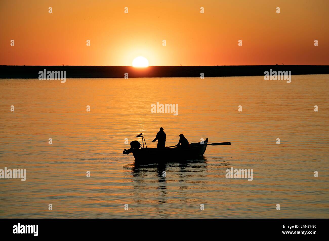 Fischer im Ruderboot bei Sonnenuntergang in der Flussmünde des Douro, Porto, Portugal. Stockfoto