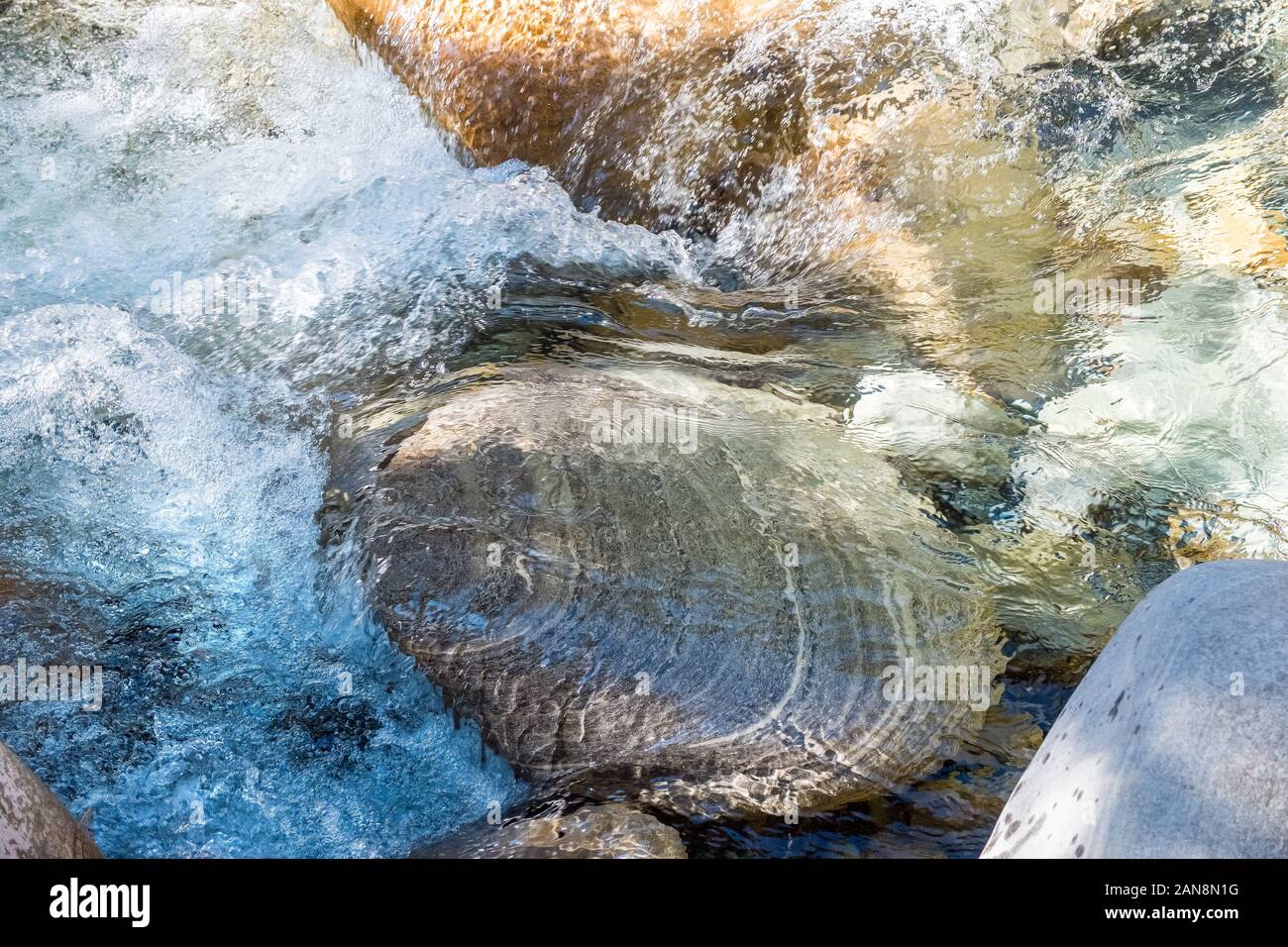 Klares Wasser im Gebirgsfluss, das über Felsbrocken im Nepal Himalaya tumbling Stockfoto