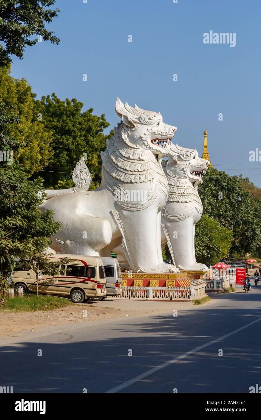 Eingang Süd an der Basis des Mandalay Hill Pagode, Mandalay, Myanmar (Birma) mit riesigen weißen chinthes Tempelwächter (Guardian Lion-Hunde) Stockfoto