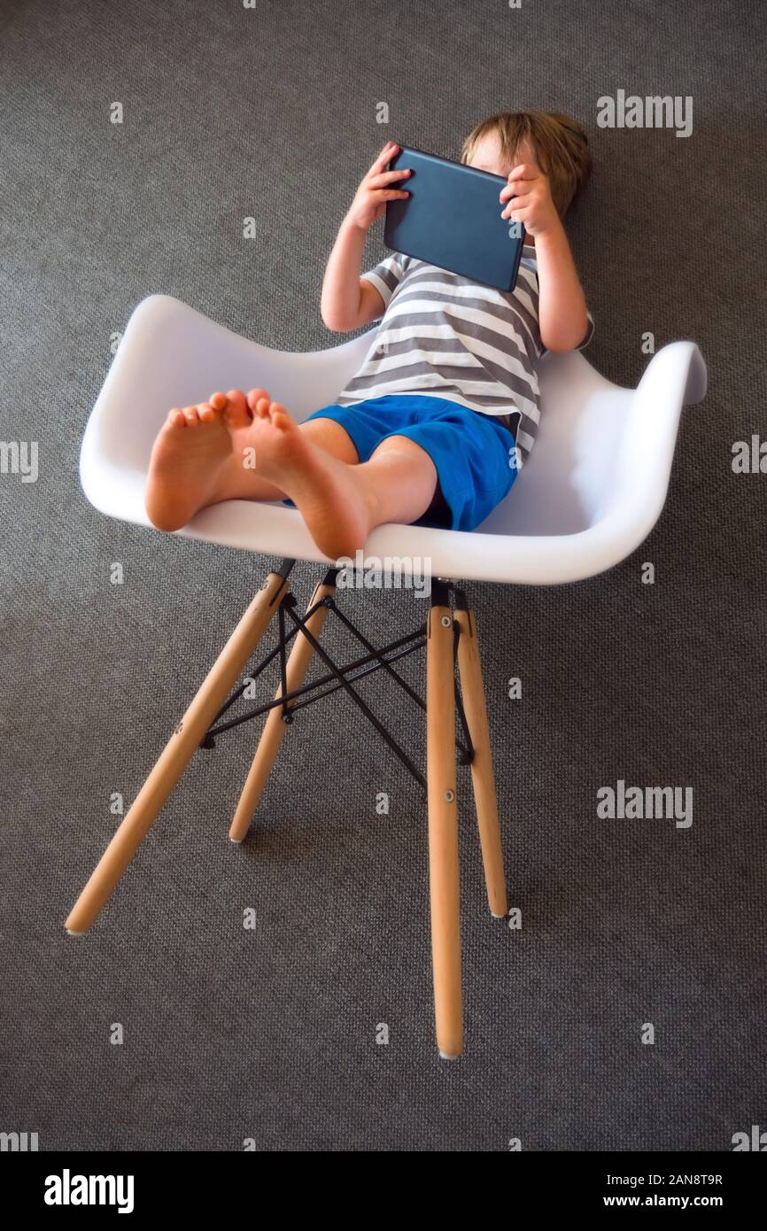 Junge mit dem Ipad. Kinder und Gadgets. Kind mit Tablet. Alternative Ausbildung Konzept. Soziale Kommunikation Störung. Digitale Zukunft. Vorschüler mit wireless Gadget. Alternative Ausbildung Stockfoto