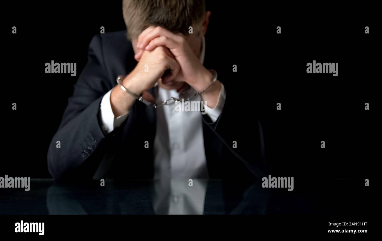 In dem Bestreben, business Mann in Handschellen sitzen auf Arbeitsplatz, illegaler Handel, Mafia Stockfoto