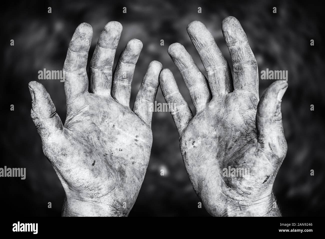 Schmutzige männliche Hände nach harter körperlicher Arbeit in einem schwarz-weißen Schuss Stockfoto