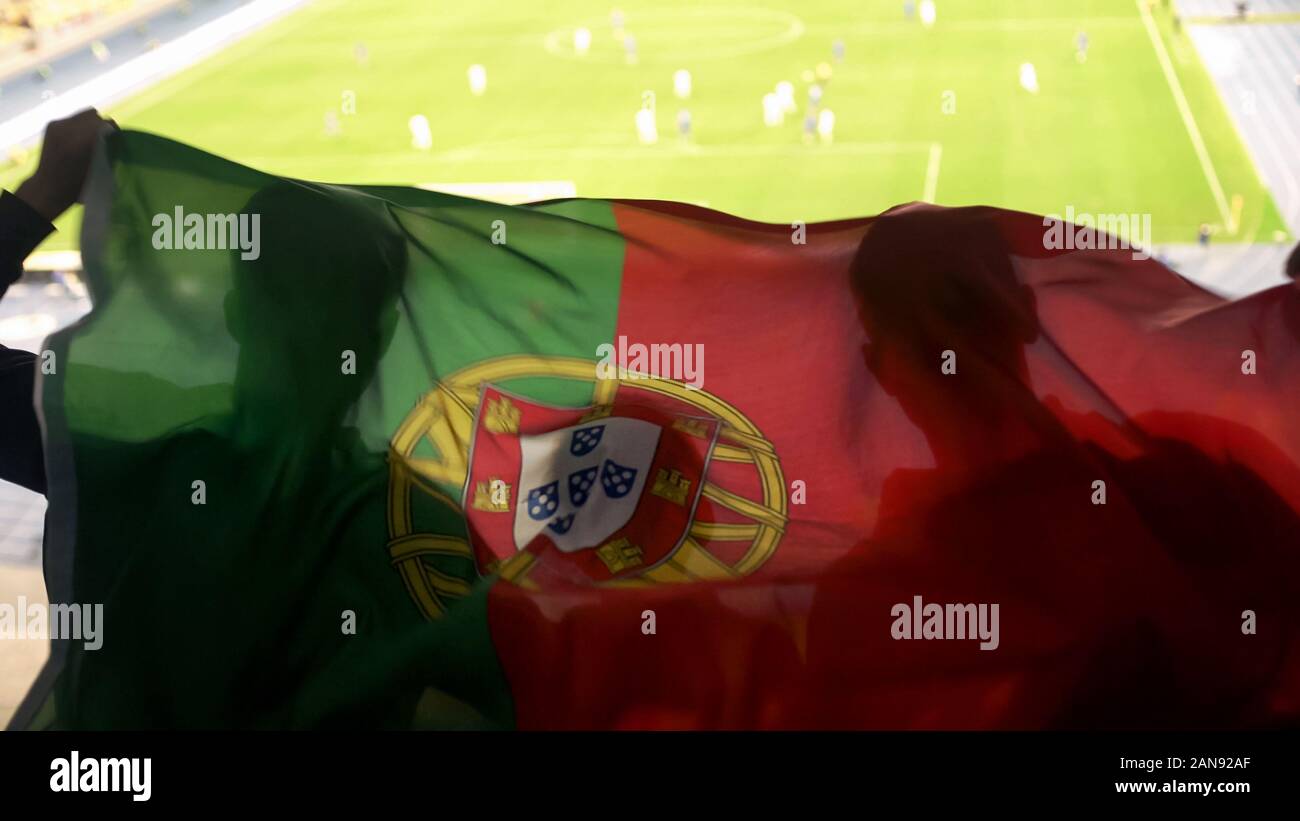Portugiesische Fans winken Nationalflagge, jubelt für Fußball-Mannschaft zum Sieg Stockfoto