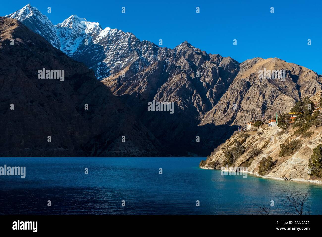 Der Phoksundo Lake, ein Gletschersee in der Dolpo-Region des Nepal-Himalayas. Über dem Wasser sitzt das Bon Buddhist Kloster / Gompa Stockfoto