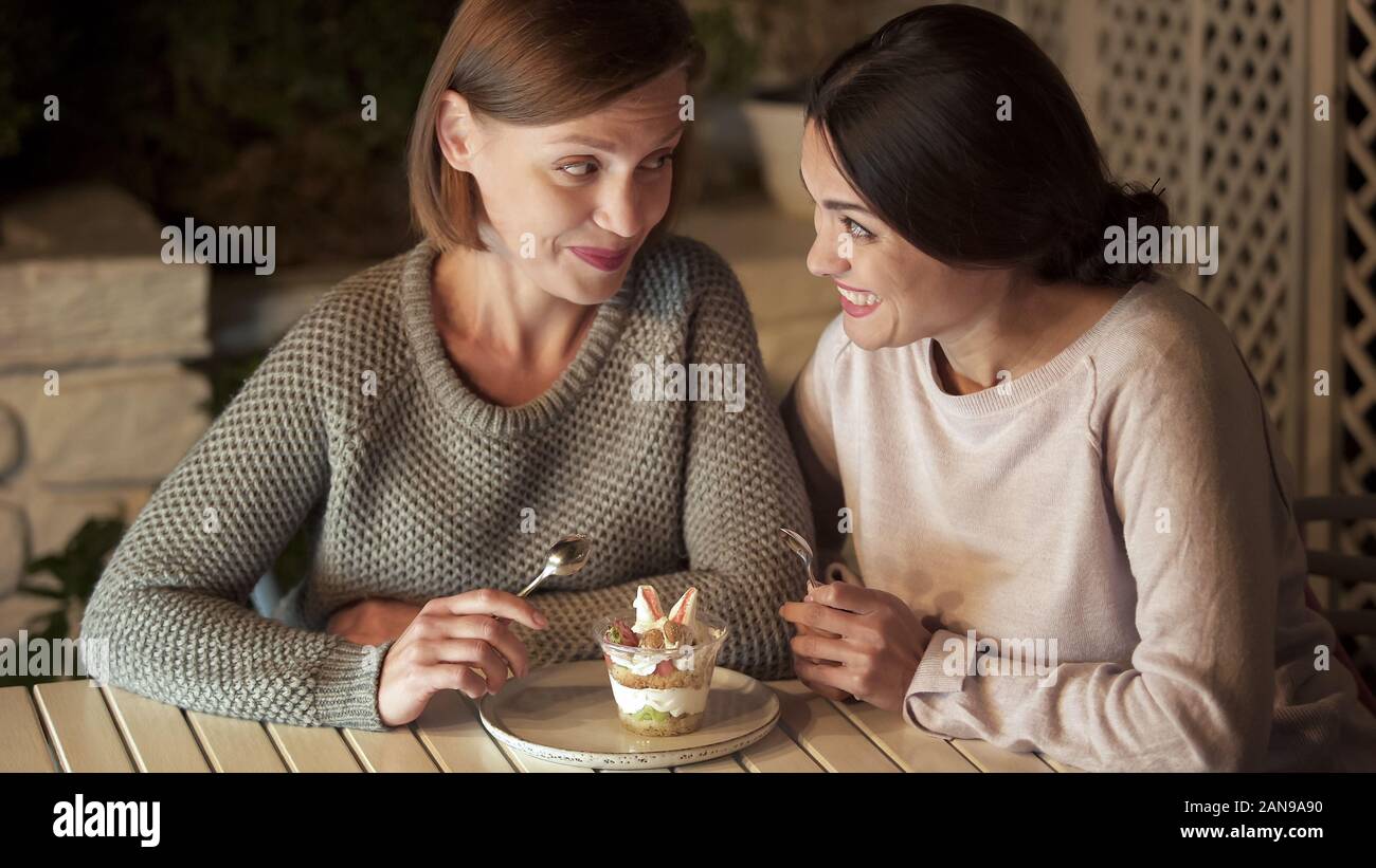 Zwei glückliche Schwestern holding Löffel, Vorbereitung von süßen cremigen Dessert Essen, Freizeit Stockfoto