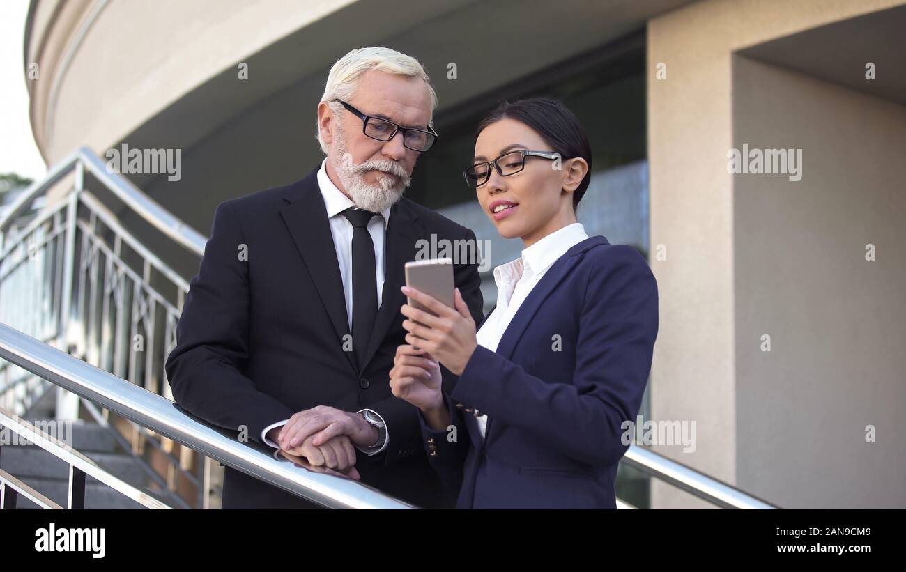 Weibliche Ratgeber zeigt alte Politiker neueste Nachrichten über das Telefon, Wahlkampf Stockfoto