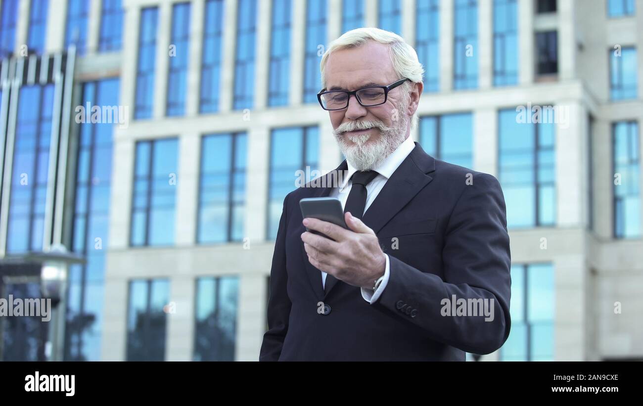 Inspiriert Mann in Anzug lesen gute Nachrichten von der Börse App für Unternehmen Stockfoto