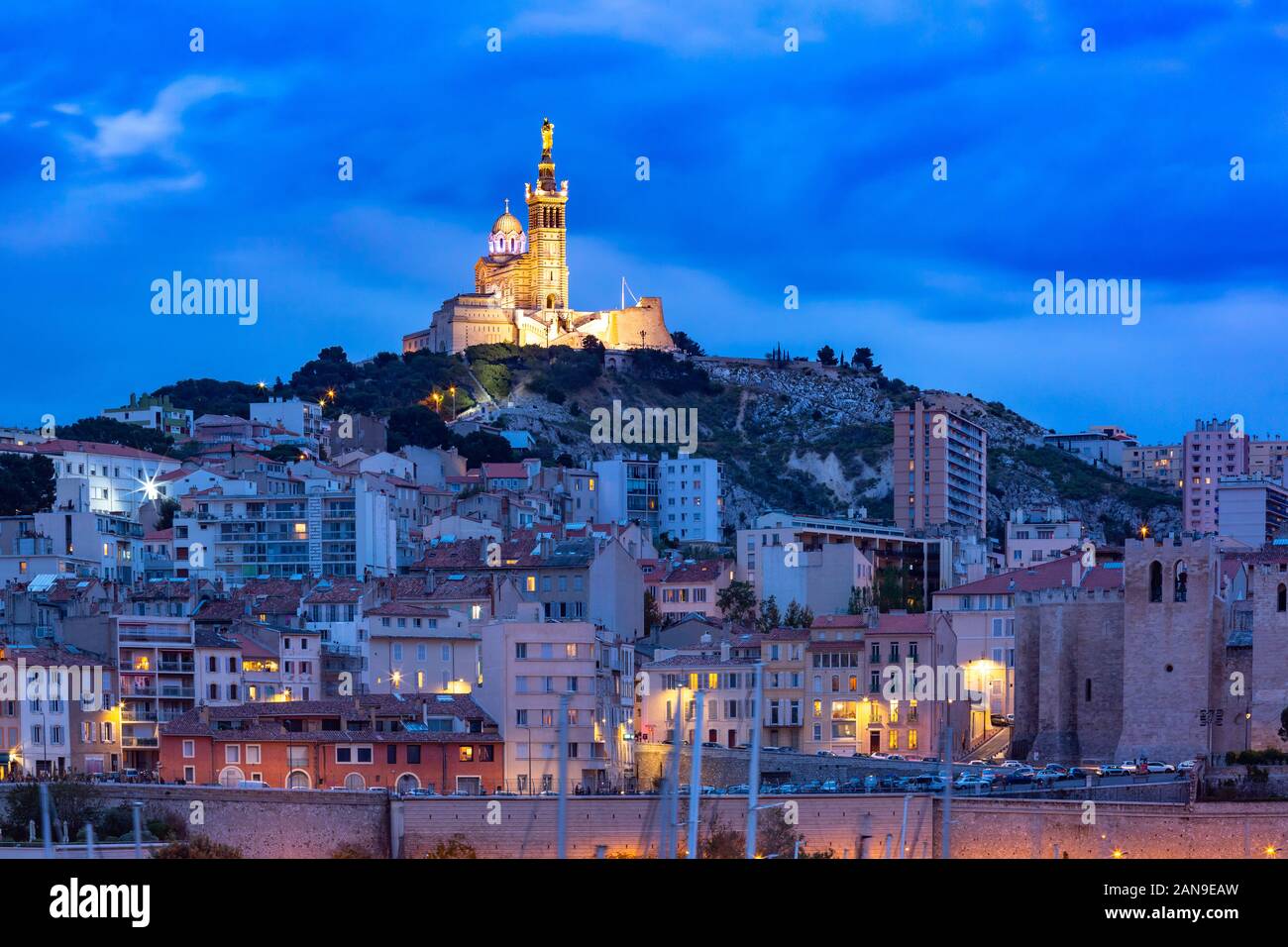 Panoramablick über Nacht den Alten Hafen und die Basilika Notre Dame de la Garde auf dem Hintergrund, auf dem Hügel, Marseille, Frankreich Stockfoto