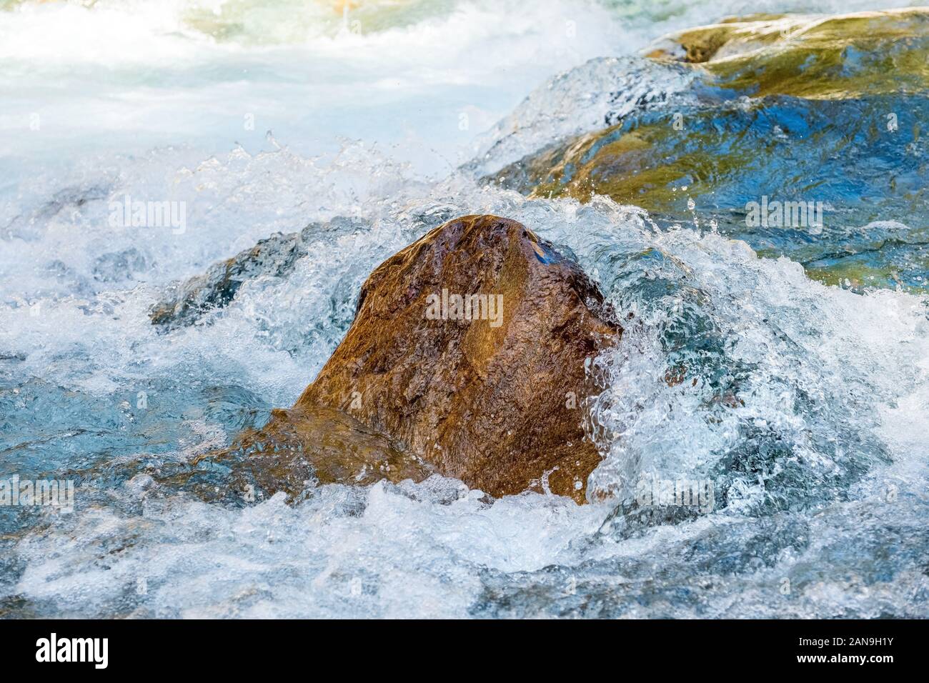 Klares Wasser im Gebirgsfluss, das über Felsbrocken im Nepal Himalaya tumbling Stockfoto