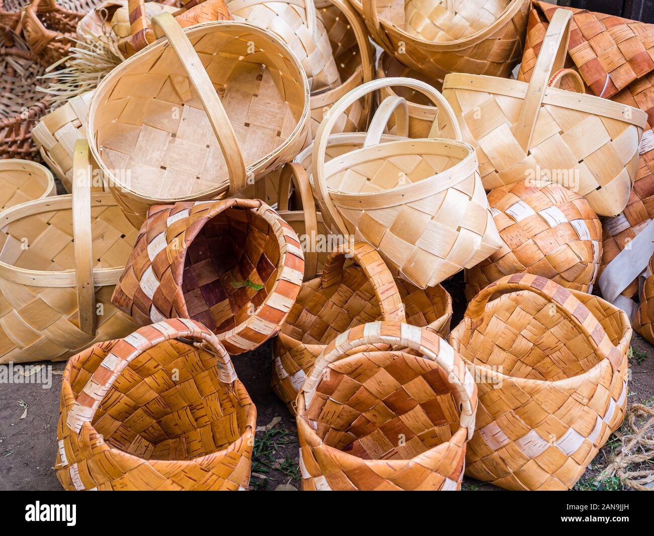 Ein Bündel Weidenkörbe im Retro-Stil. Haufen birke Körbe. Stapel der Birkenrinde bast Körbe. Stockfoto