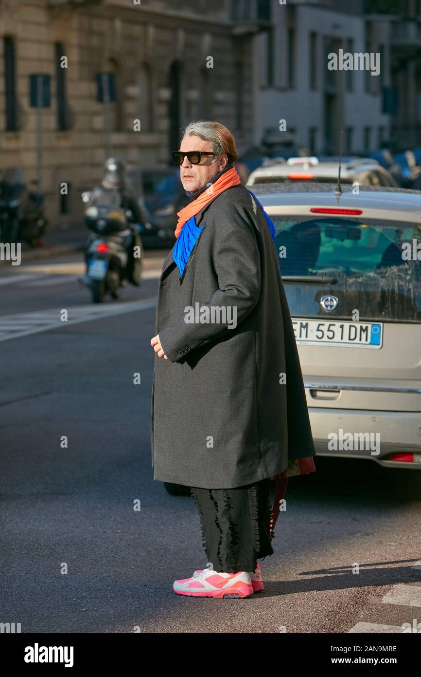 Mailand, Italien - Januar 12, 2019: Mann mit rosa Turnschuhe und orange und blau Schal vor Salvatore Ferragamo fashion show, Mailand Fashion Week Straße s Stockfoto