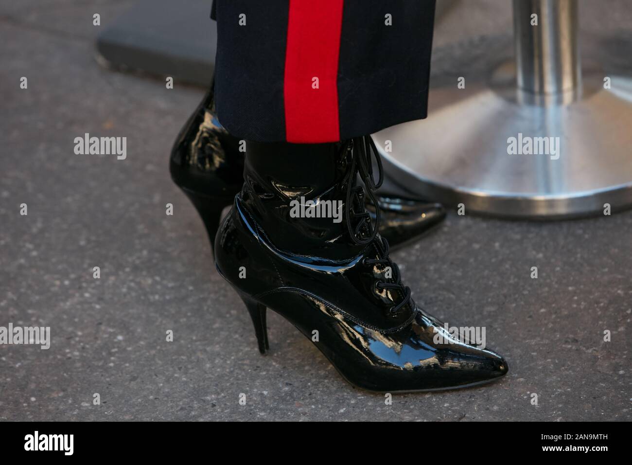 Mailand, Italien - Januar 12, 2019: Frau mit High Heel glänzende Schuhe und schwarze Hose mit roten Streifen, bevor Salvatore Ferragamo fashion show, Mailand Fa Stockfoto