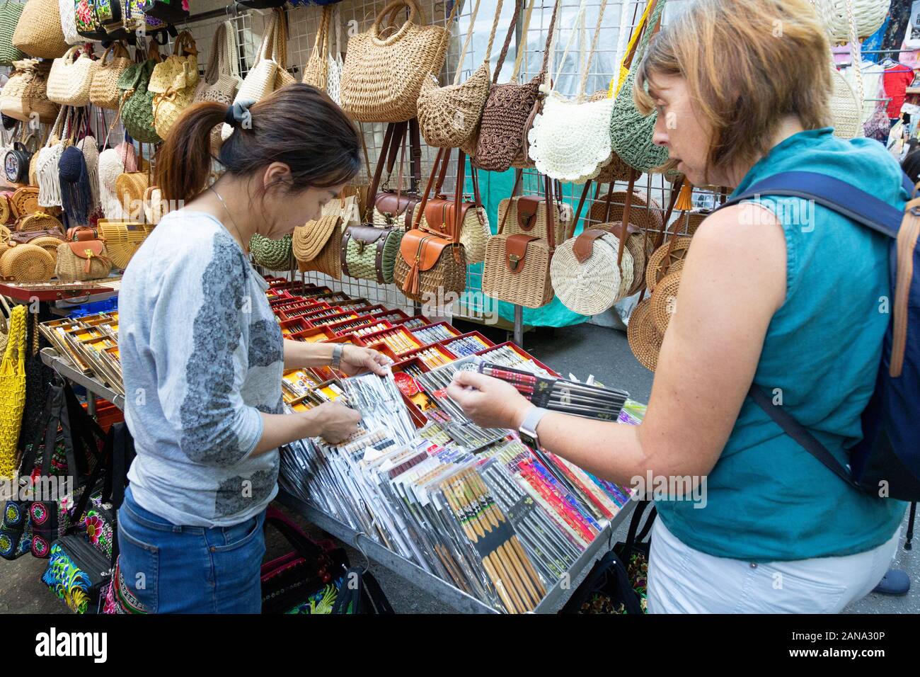 Hong Kong Tourist - eine Frau touristische Shopping in Kowloon Markt, Essstäbchen kaufen von einem Stall, Kowloon Hong Kong Asien Stockfoto