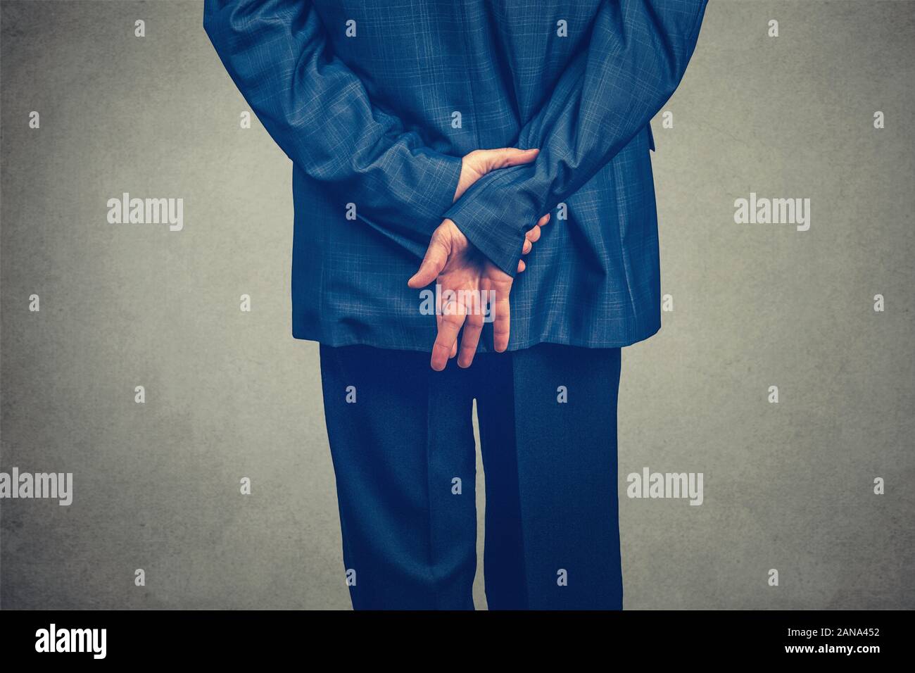 Schwor einen Eid mit den Fingern hinter dem Rücken gekreuzt, Konzept für Unehrlichkeit oder Geschäft betrug. Modell Blue Navy Anzug mit, 7/8 Körper auf g isoliert Stockfoto