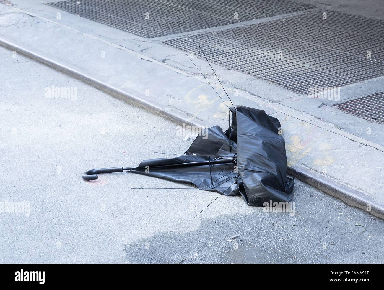 Eine verlassene, gebrochen Sonnenschirm auf einer Straße zu bändigen. Stockfoto