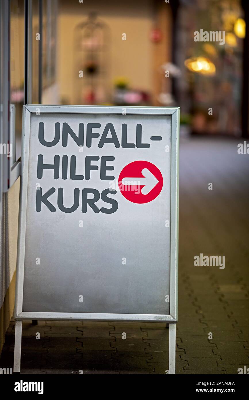 Schild mit roter Pfeil, der auf dem Weg zum Standort der Erste Hilfe Kurs, Text in deutscher Sprache Erste Hilfe Kurs Stockfoto