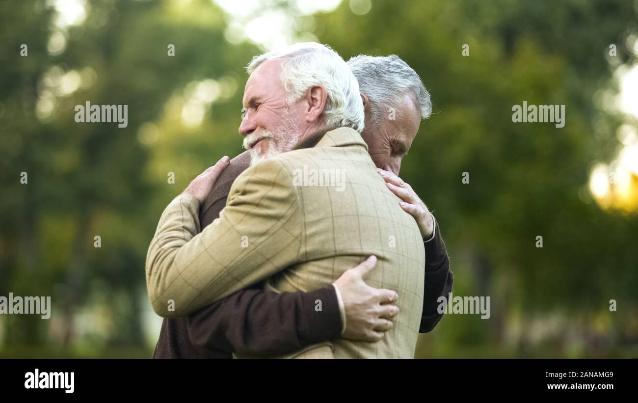 Reife Männer umarmen, glücklich miteinander, alte Freunde treffen, um zu sehen, Gruß Stockfoto