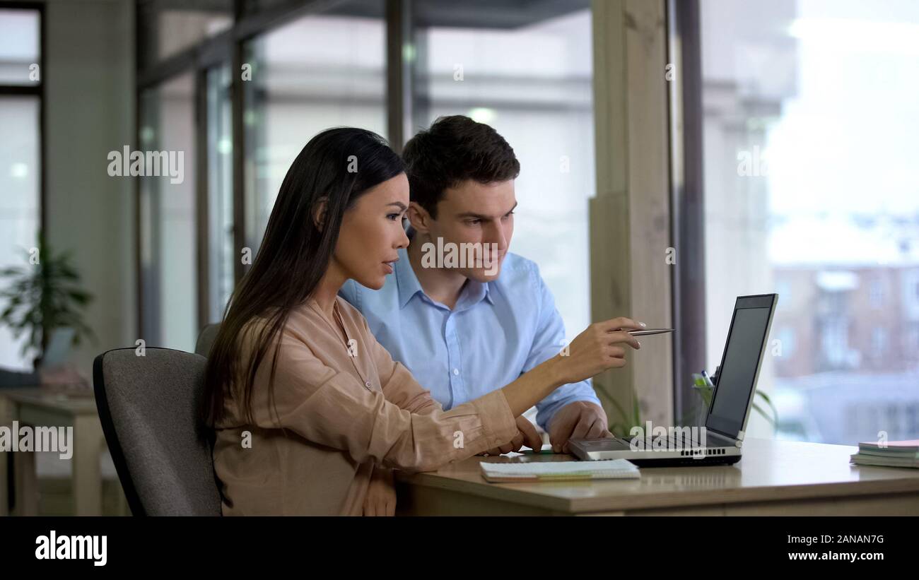 Weibliche und männliche Mitarbeiter lesen E-laptop, Planung Strategie, Diskussion Stockfoto