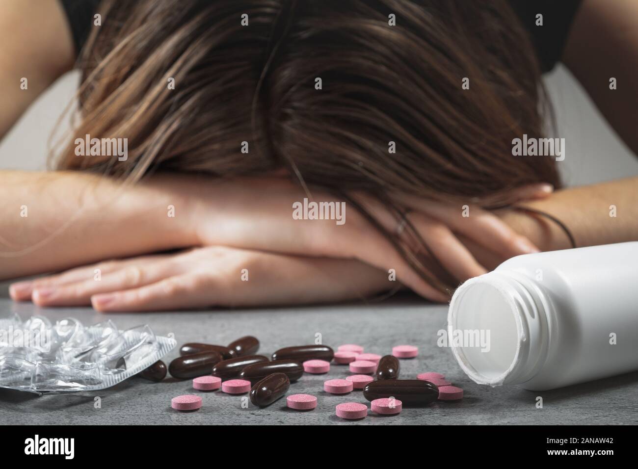 Konzept von Drogen missbrauchen. Weibchen mit dem Kopf auf dem Tisch vor Pillen und verschreibungspflichtige Stoffe, Konzept der Depressionen oder Selbstmord attmept Stockfoto
