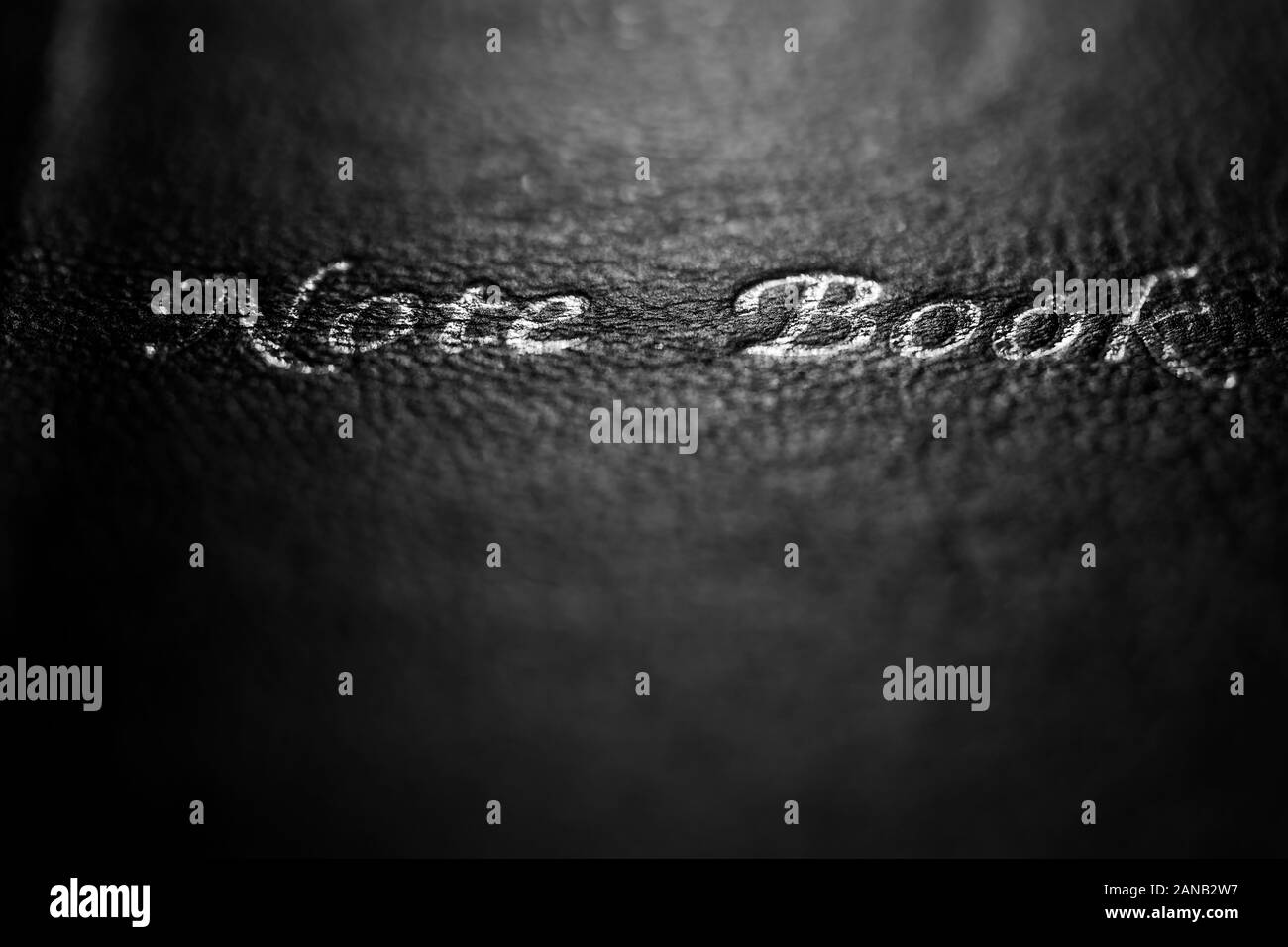 Close-up des Schwarzen lerike Oberfläche eines Buch Cover mit den Worten Hinweis Buch in einem dunklen Erscheinung. Stockfoto