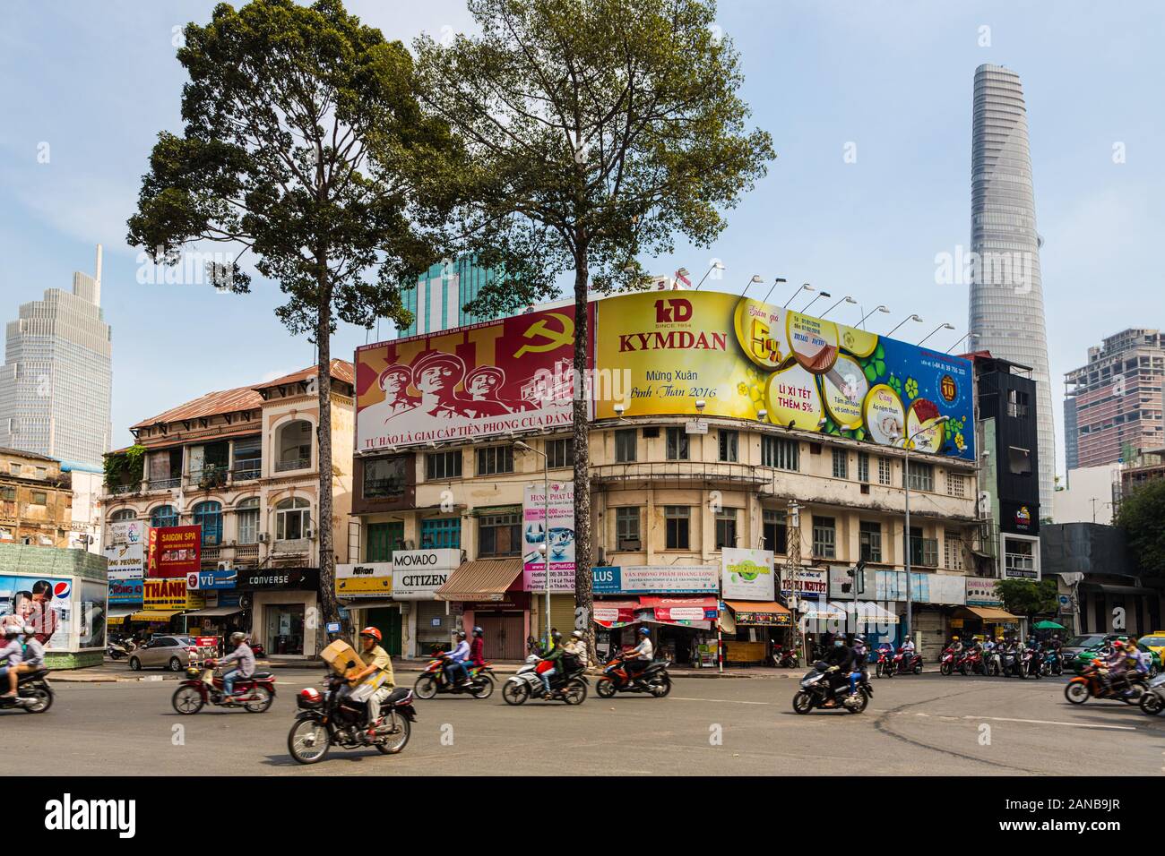 Ho Chi Minh City, Vietnam - 29. Mai 2018: Motorräder fahren, in einer Straße, in der der Kommunismus propaganda Gegensatz kommerzielle Werbung in Ho Chi Min. Stockfoto
