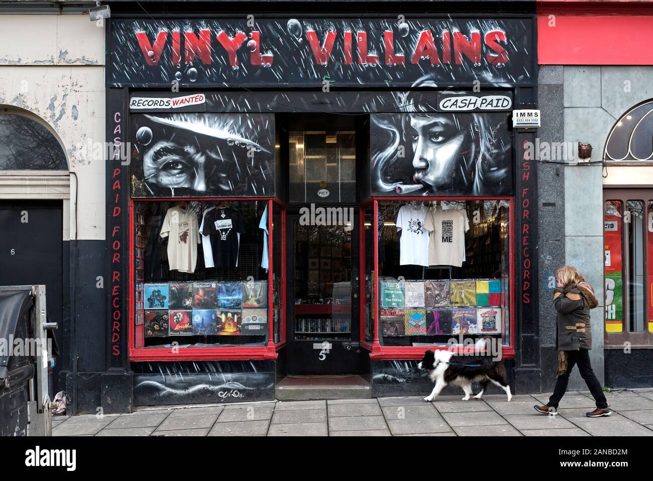 Eine Frau und ihr Hund Spaziergänge durch Vinyl Villans, eine unabhängige Datensätze gespeichert Verkauf von neuen und gebrauchten Schallplatten und CDs auf Elm Row, Edinburgh, Schottland. Stockfoto