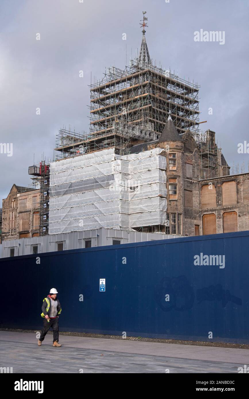 Ein Arbeiter geht vorbei an der alten königlichen Krankenhaus auf der Quartermile, wird saniert für Edinburgh Futures Institut, Universität Edinburgh. Stockfoto