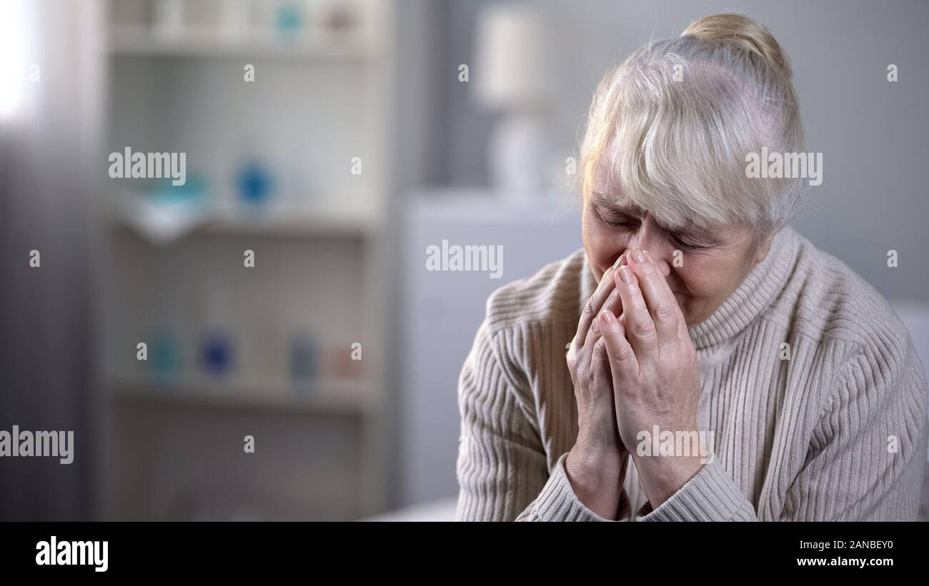 Ältere Dame allein im Pflegeheim Sitzung verärgert und tief Schreien, Einsamkeit Stockfoto