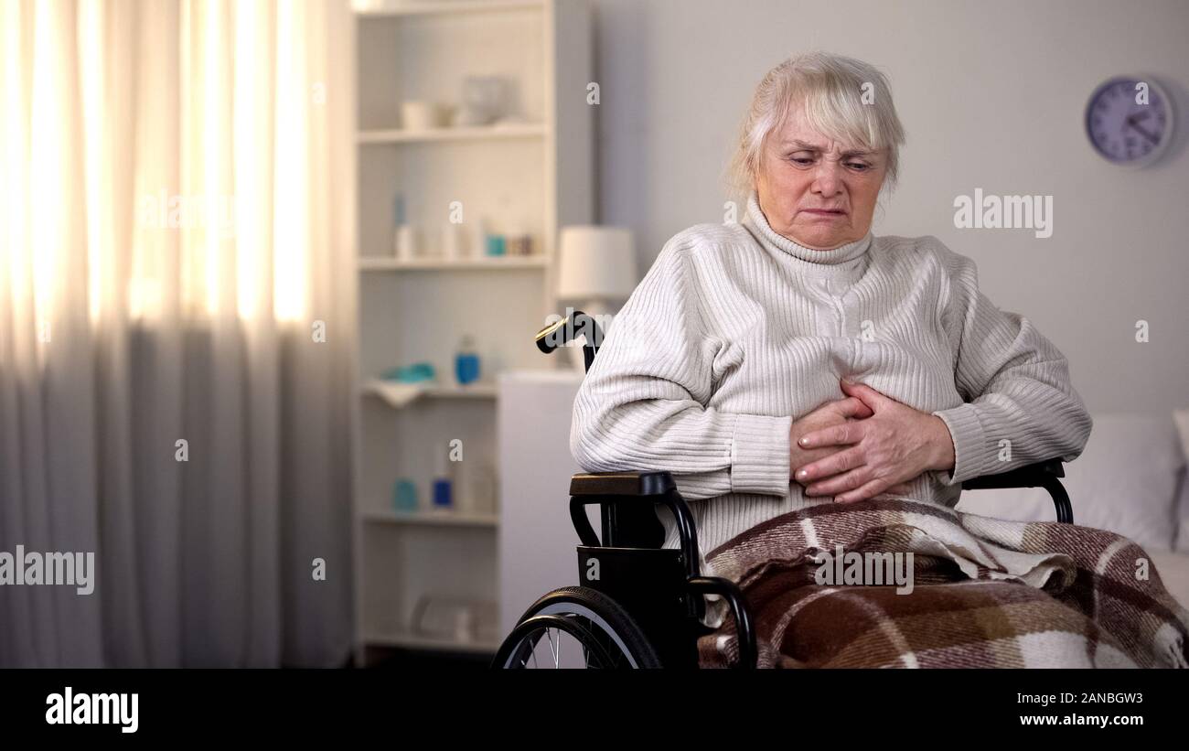 Behinderte alte Frau mit Bauchschmerzen, Gesundheitswesen, Gastritis Stockfoto