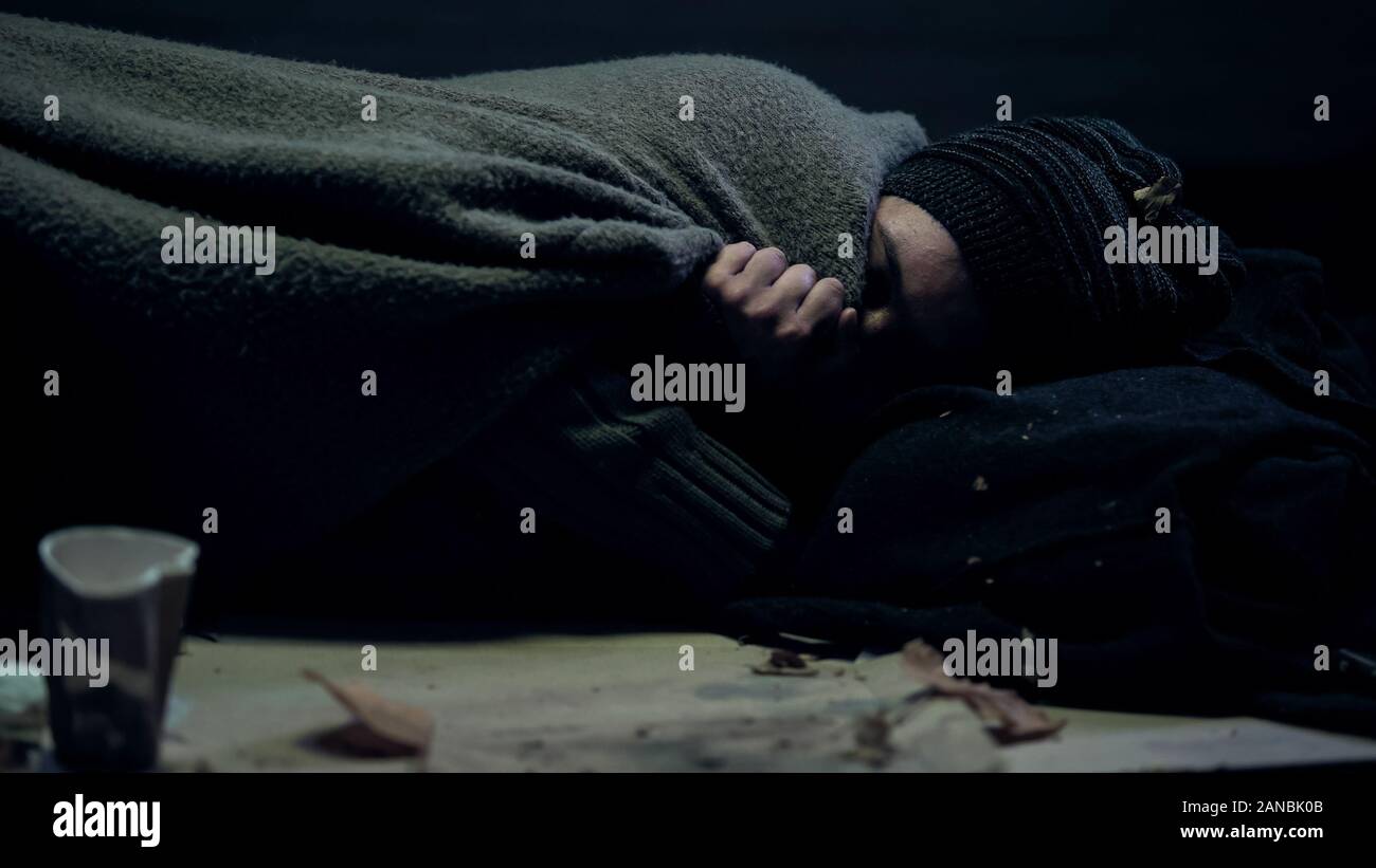 Armer Bettler abgedeckt schmutzige Decke schlafen auf der Straße frieren, Obdachlosigkeit Stockfoto