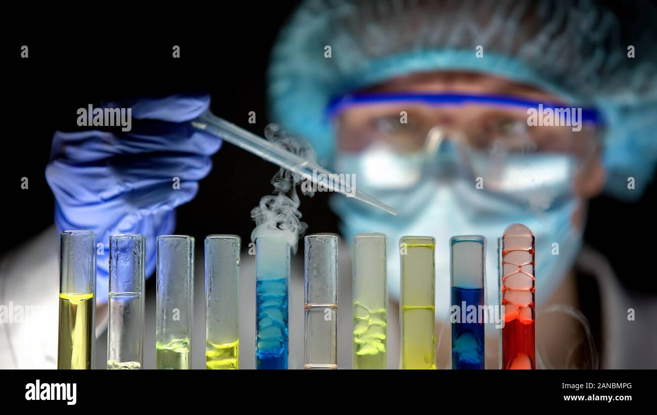 Forscher chemische Flüssigkeit tropft durch die Pipette in Röhren, Kontrolle Reaktion Stockfoto