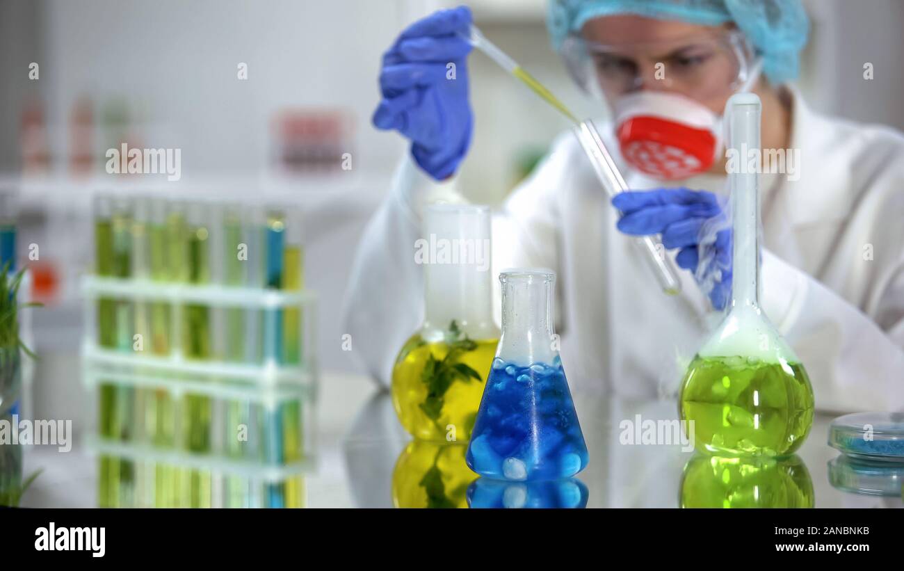 Labor Forscher gießen gelbe Flüssigkeit in das Rohr zur Analyse, Kosmetologie Stockfoto