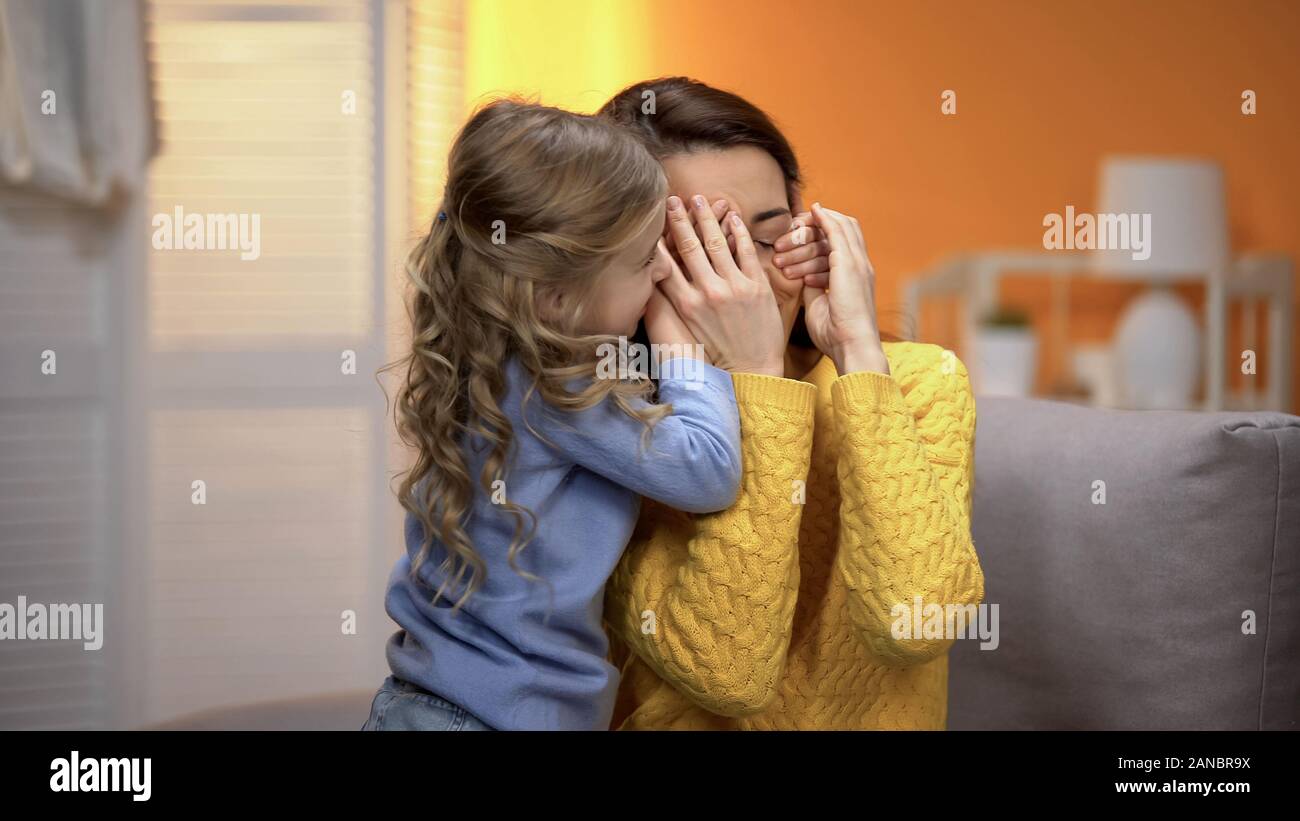 Adorable kleine Mädchen schließen Mütter Augen mit den Händen, glückliche Familie Momente Stockfoto